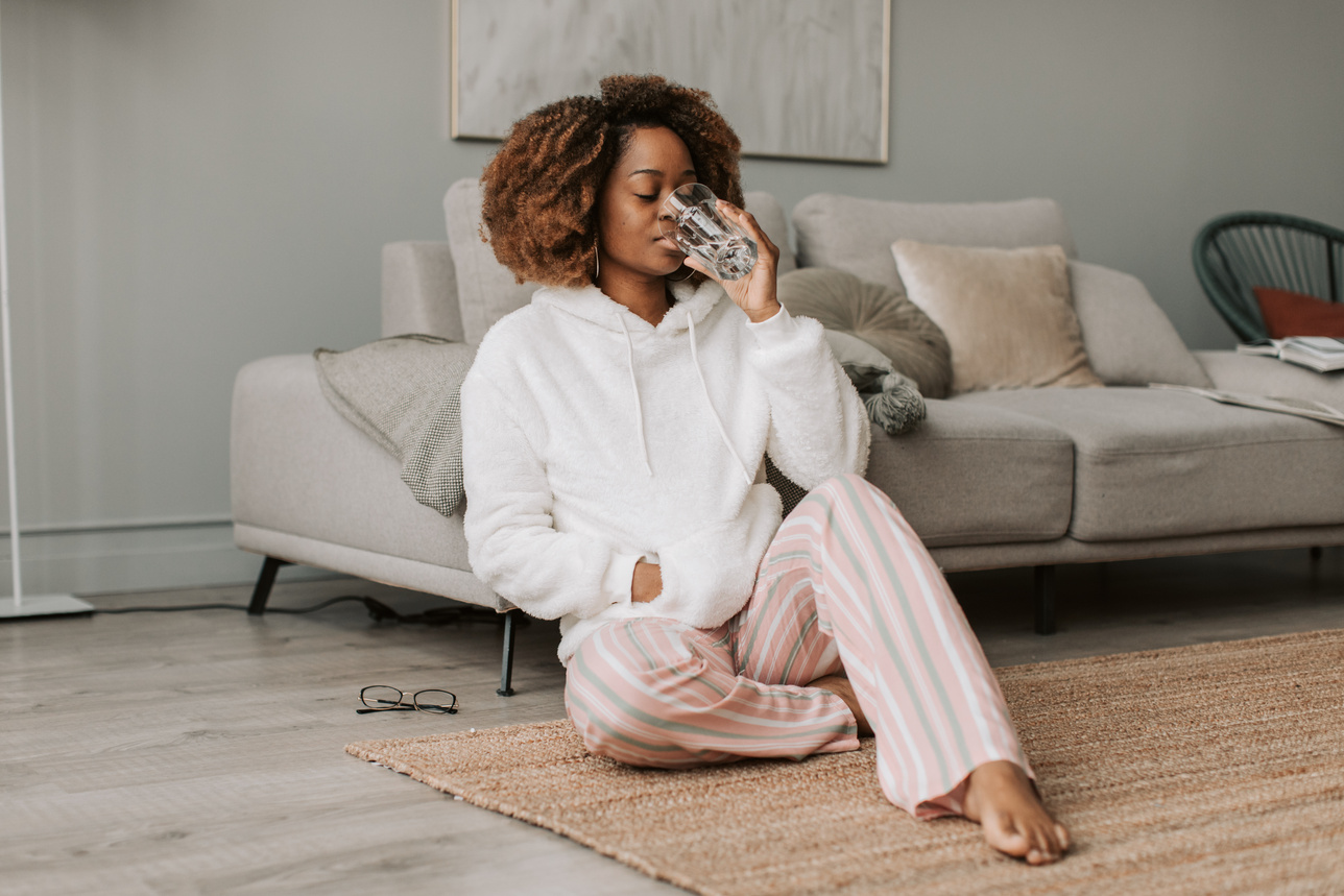 Woman in White Hoodie Drinking Water